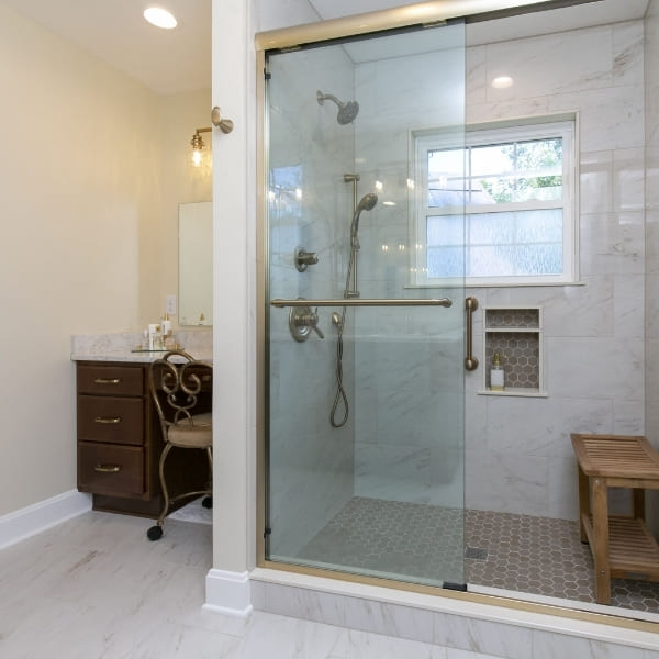 Sliding Glass Door Walk-In Shower with Seating Bench and Adjacent Vanity Area in Primary Bathroom | Louisville Handyman and Remodeling